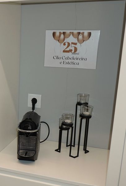 Pormenor do salão: máquina de café, castiçais e o quadro dos 25 anos da Cila